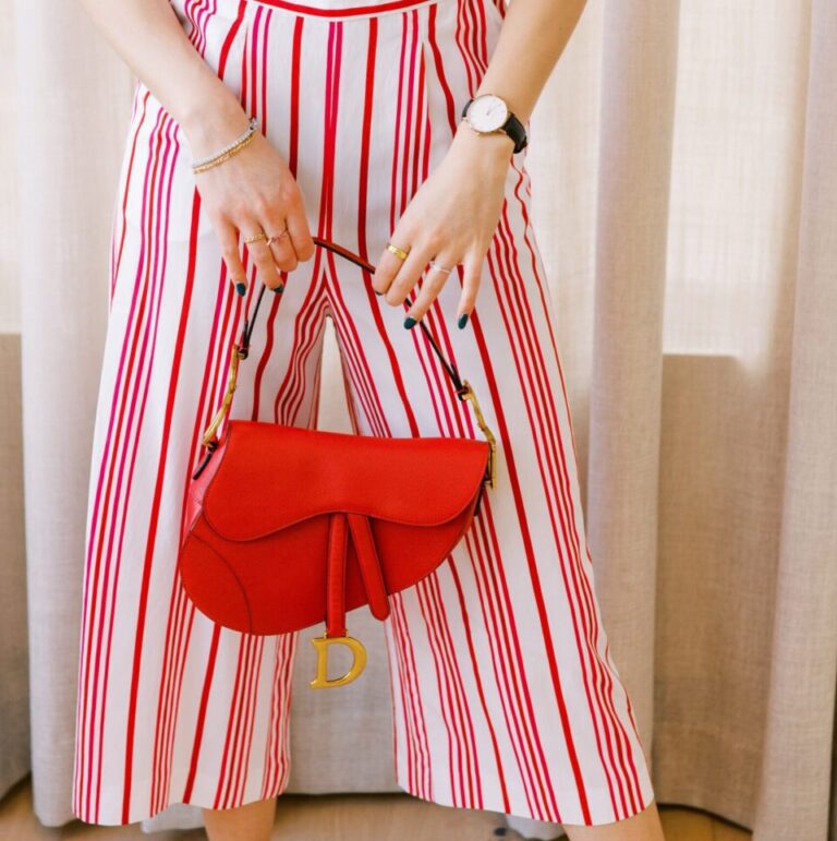Woman in french inspired playsuit holding red Dior saddle bag | Ode2style.com