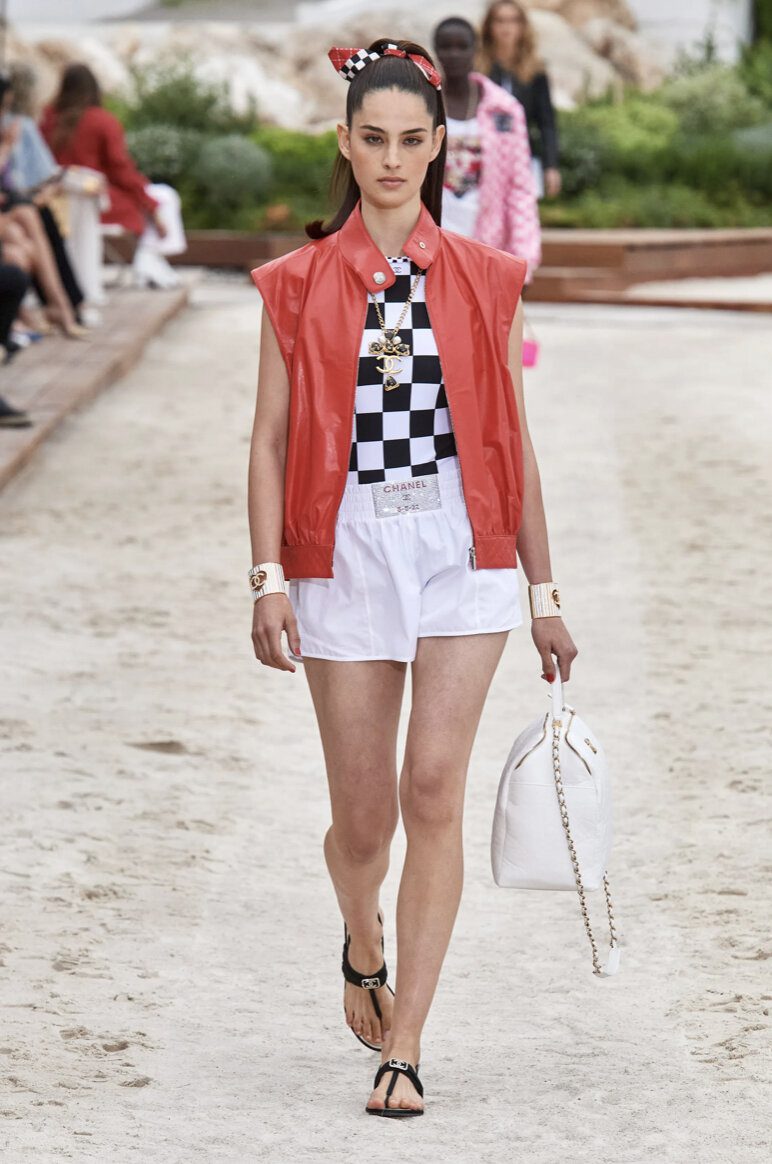 Woman in white boxer shorts and a red jacket at the Chanel cruise 2023 show | Ode2style.com
