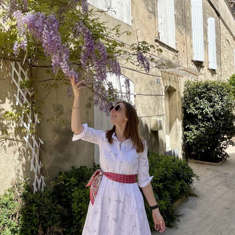 Astrid in a white embroidered dress smelling flowers in the Provence, France | Ode2style.com