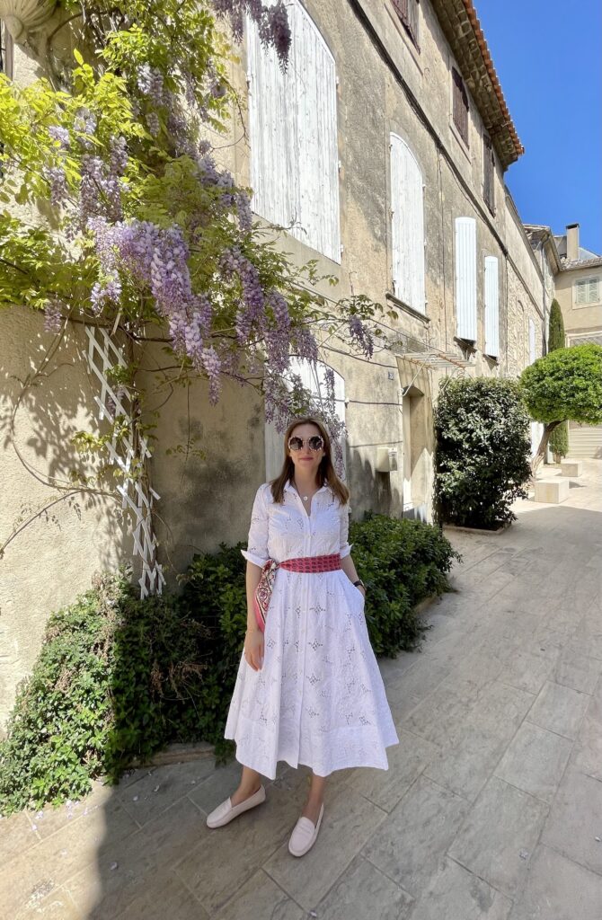 Astrid in a flower covered alley in Saint Remy de Provence wearing a white embroidered dress from Souleiado | Ode2style.com