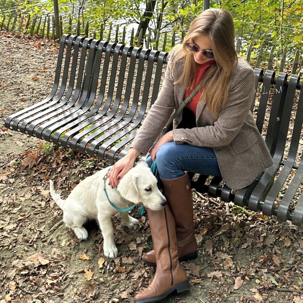 Astrid in equestrian inspired look with calf length camel boots, brown herringbone blazer on a bench in a park with a puppy | Ode2style.com