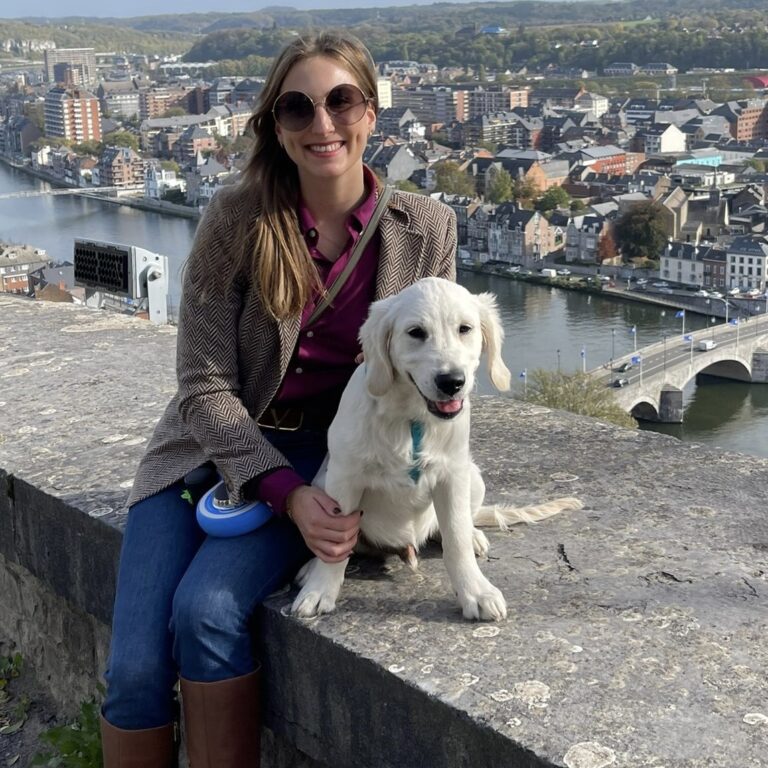 Astrid with golden retriever whiskey sitting in front of a view of the Belgian city Namen | Ode2style.com