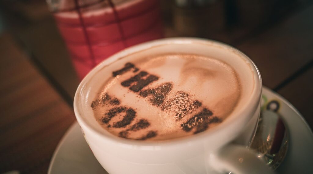 A coffee cup with the writing 'thank you' in the cream layer